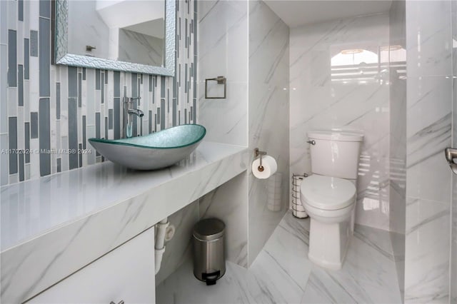 bathroom featuring sink and tile walls