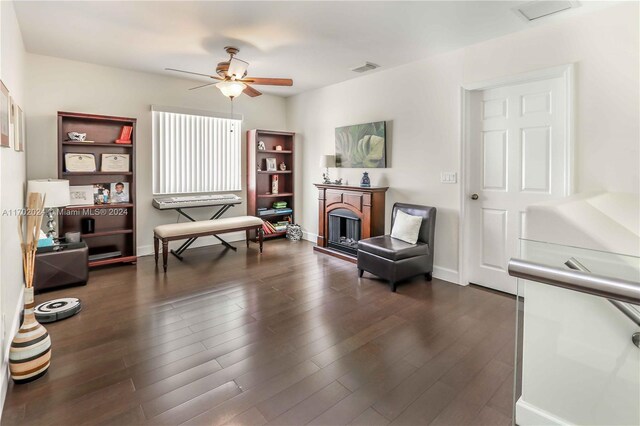 sitting room with ceiling fan and dark hardwood / wood-style flooring