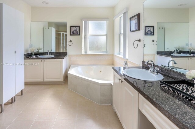 bathroom with plus walk in shower, tile patterned flooring, and vanity