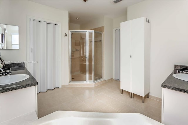 bathroom featuring tile patterned flooring, vanity, and a shower with shower door