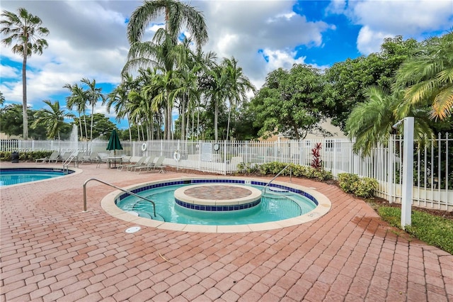 view of swimming pool featuring a hot tub and a patio area