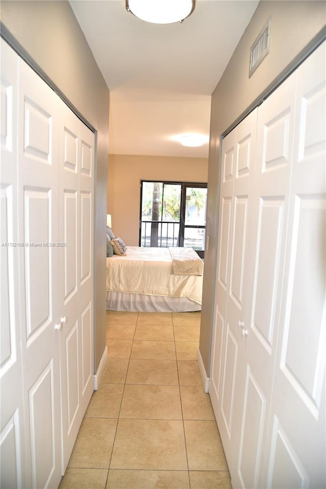 hallway featuring light tile patterned flooring and visible vents