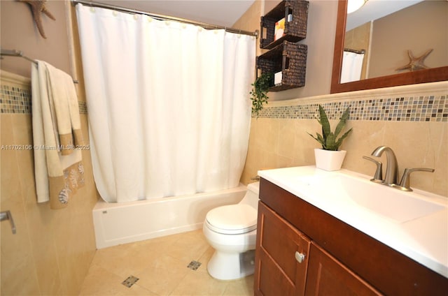 bathroom featuring tile walls, shower / bath combination with curtain, toilet, vanity, and tile patterned floors