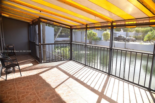 unfurnished sunroom featuring a water view