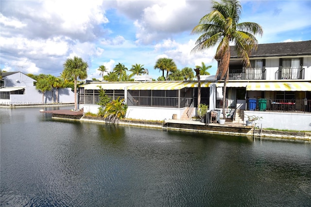 rear view of property featuring a water view and a sunroom