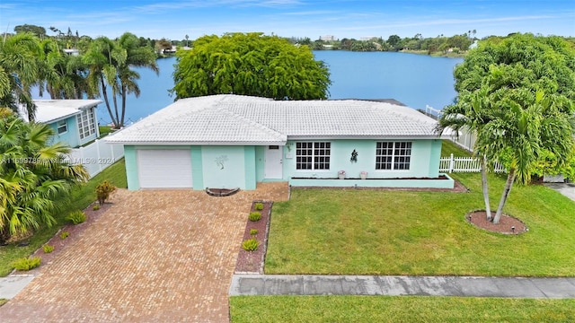 ranch-style home with a garage, a water view, and a front yard