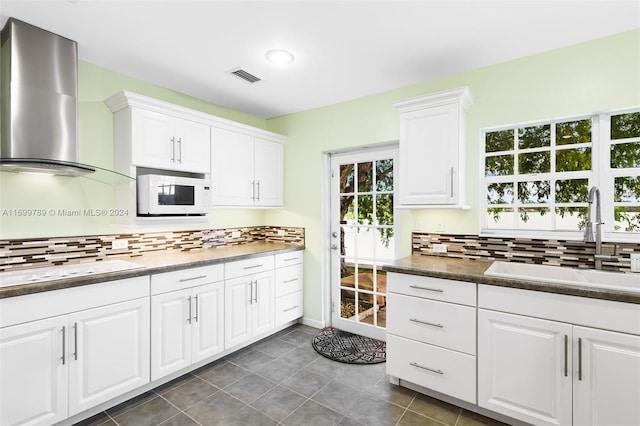 kitchen with backsplash, wall chimney exhaust hood, sink, and white cabinets