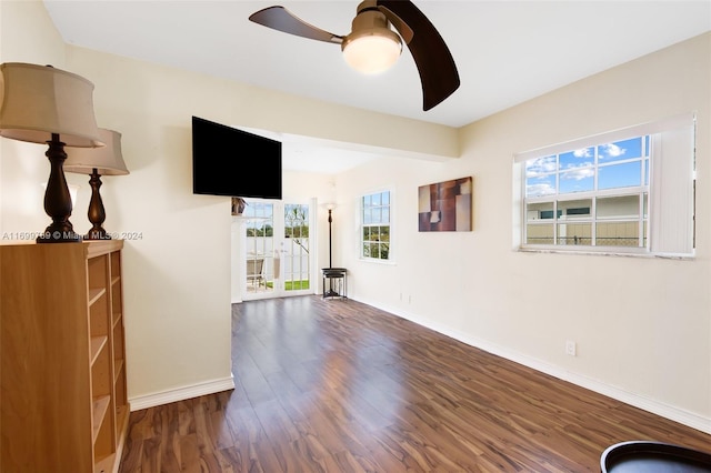 unfurnished living room with dark hardwood / wood-style floors and ceiling fan