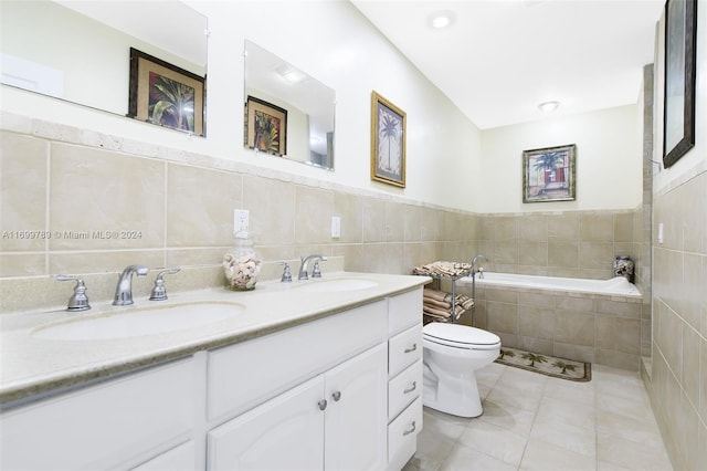 bathroom with vanity, tile patterned floors, a relaxing tiled tub, toilet, and tile walls