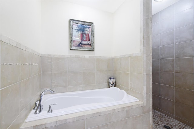 bathroom with a relaxing tiled tub