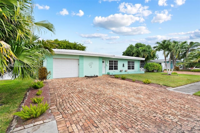 single story home with a garage and a front lawn