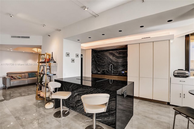 kitchen featuring white cabinetry and sink