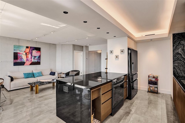 kitchen featuring track lighting, a large island, and black appliances