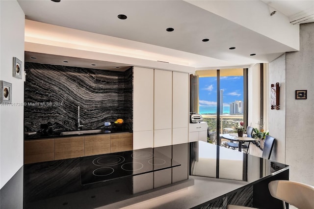 kitchen featuring black electric cooktop and a wall of windows