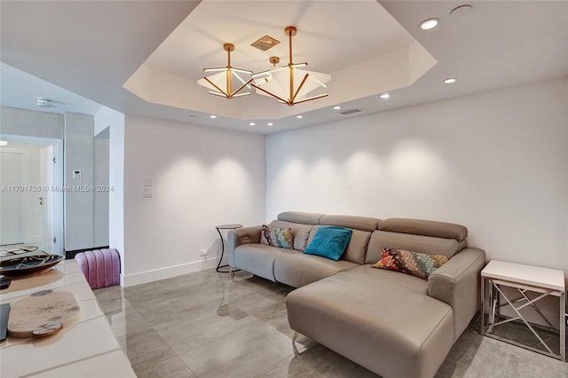 living room featuring a notable chandelier and a tray ceiling