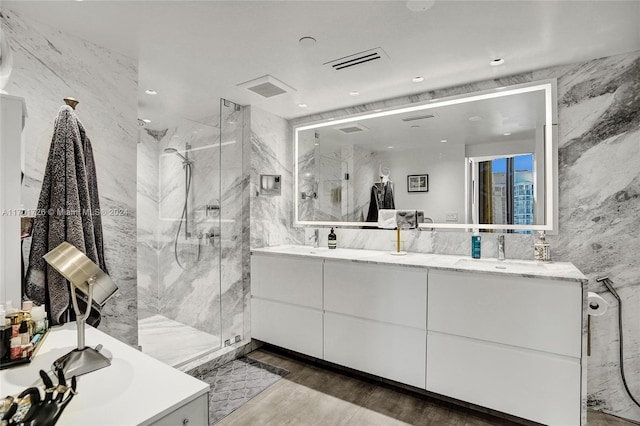 bathroom featuring an enclosed shower, wood-type flooring, vanity, and tile walls