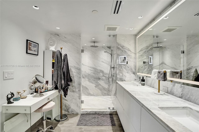 bathroom featuring vanity, a shower with shower door, and tile walls