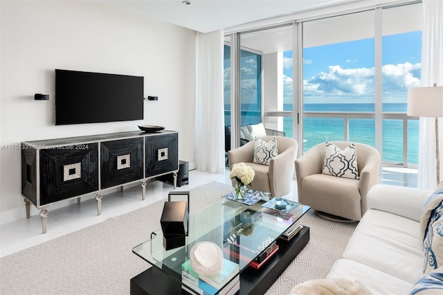 living room with tile patterned floors, a water view, a wall of windows, and a wealth of natural light