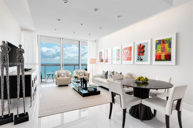 dining space with a water view, light tile patterned floors, and a wall of windows