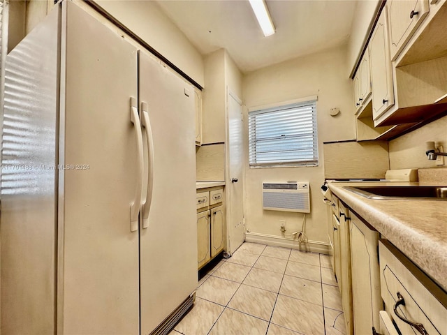 kitchen featuring an AC wall unit, sink, white fridge, and light tile patterned floors