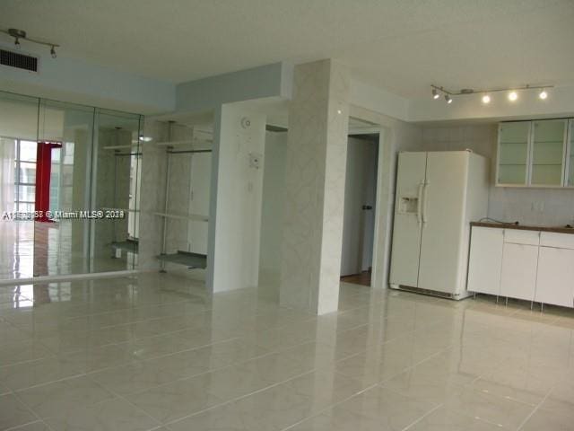 spare room featuring light tile patterned floors and track lighting