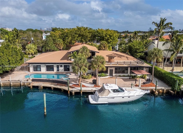 back of house with a water view and a patio