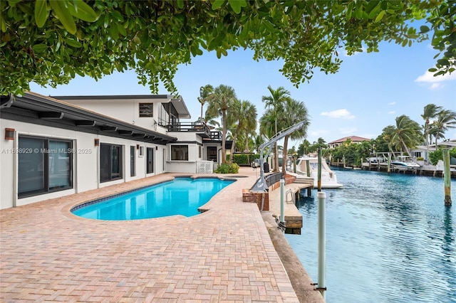 view of swimming pool with a water view, a water slide, and a patio