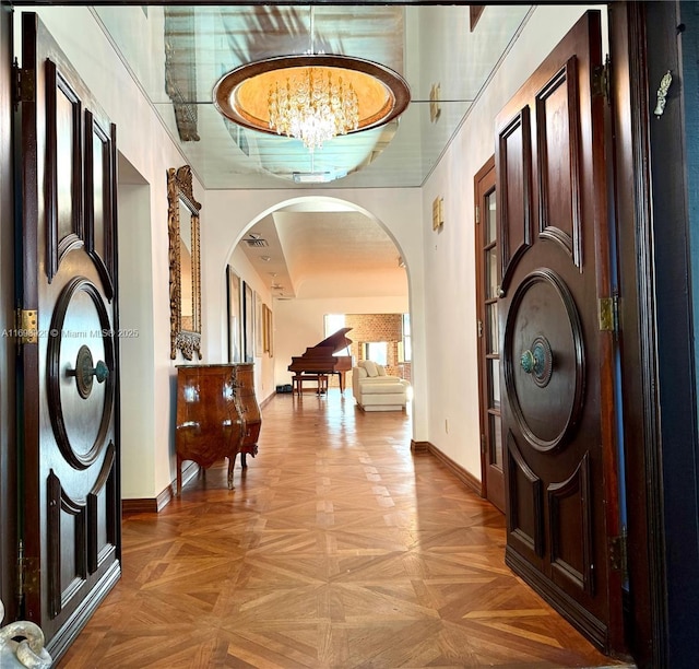 foyer featuring an inviting chandelier and light parquet flooring