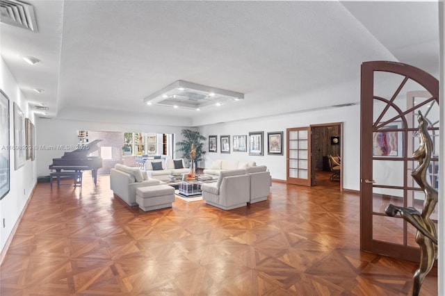 living room featuring parquet flooring, french doors, and a textured ceiling