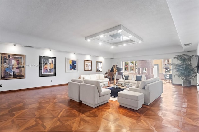 living room featuring parquet floors, a tray ceiling, and a textured ceiling