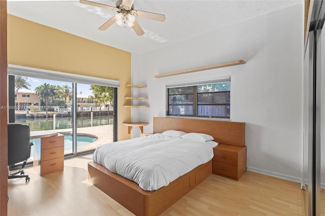 bedroom featuring a water view, ceiling fan, access to exterior, and light hardwood / wood-style floors