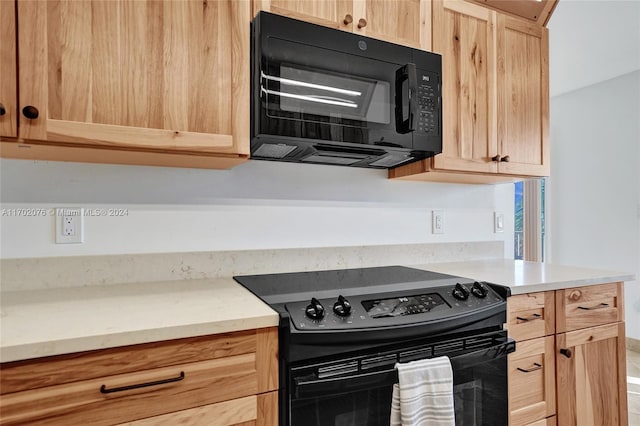 kitchen with light brown cabinets and black appliances