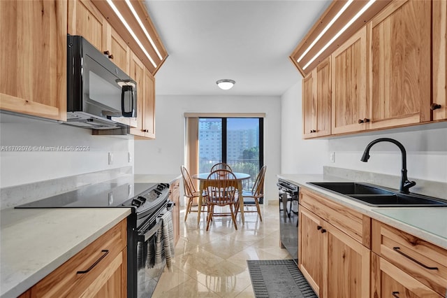 kitchen featuring light brown cabinetry, sink, and black appliances