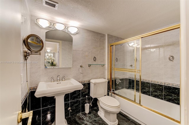 1849 S Ocean Dr Unit 1412, Hallandale Beach, FL 33009 - full bathroom featuring tile walls, toilet, a textured ceiling, shower / bath combination with glass door, and marble finish flooring