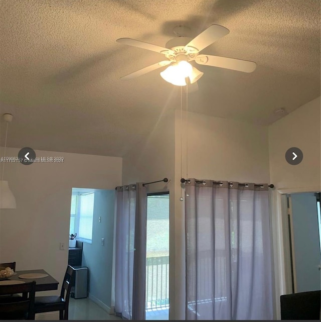 details featuring ceiling fan, a water view, and a textured ceiling