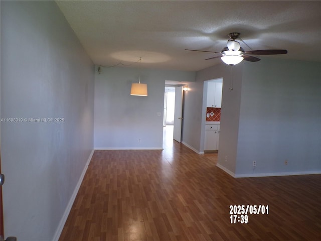 empty room featuring baseboards, ceiling fan, and wood finished floors