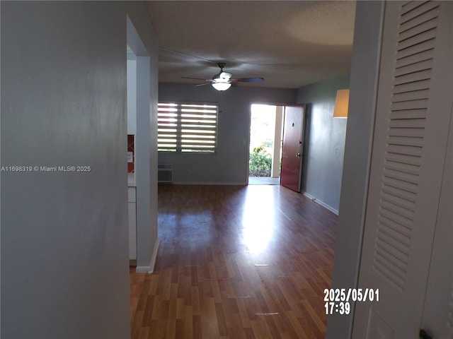 corridor featuring baseboards and wood finished floors