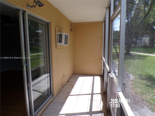 unfurnished sunroom featuring plenty of natural light and a wall unit AC