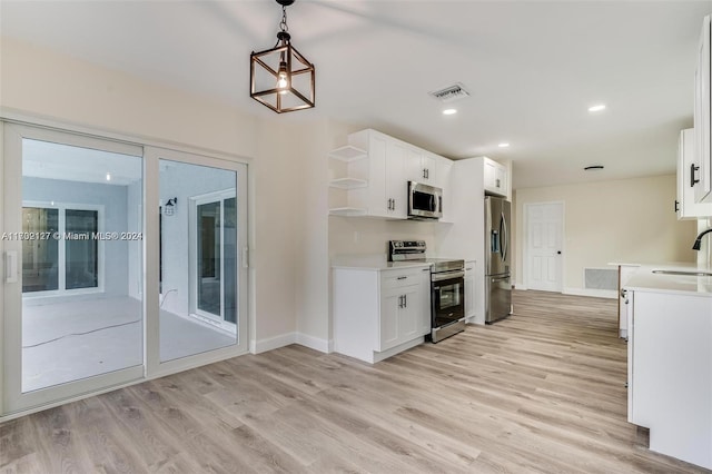 kitchen featuring white cabinets, sink, hanging light fixtures, light hardwood / wood-style floors, and stainless steel appliances