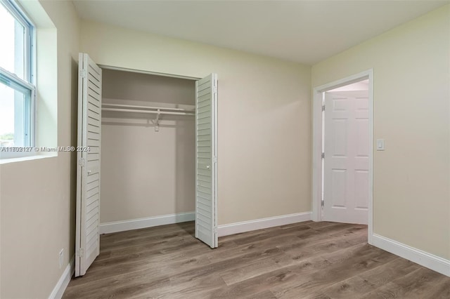 unfurnished bedroom featuring hardwood / wood-style floors and a closet