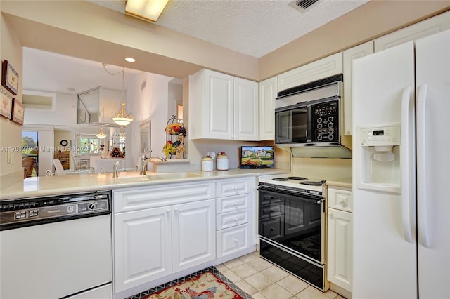 kitchen featuring white appliances, white cabinets, sink, light tile patterned floors, and a textured ceiling