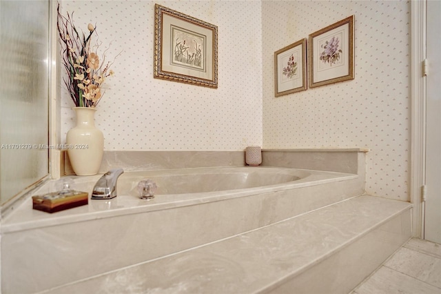 bathroom with tile patterned floors and a washtub