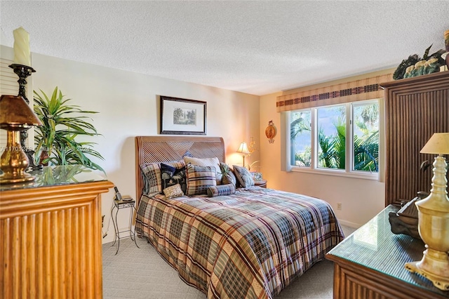 bedroom with light carpet and a textured ceiling