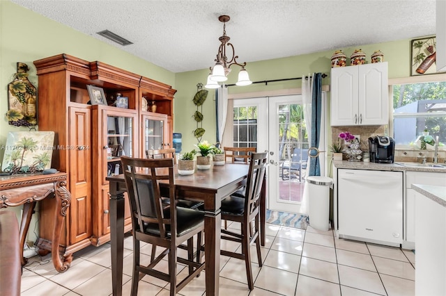 dining room with french doors, a textured ceiling, light tile patterned floors, and a notable chandelier