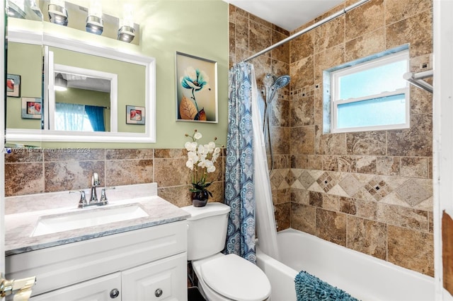 full bathroom with vanity, toilet, tile walls, and shower / tub combo with curtain