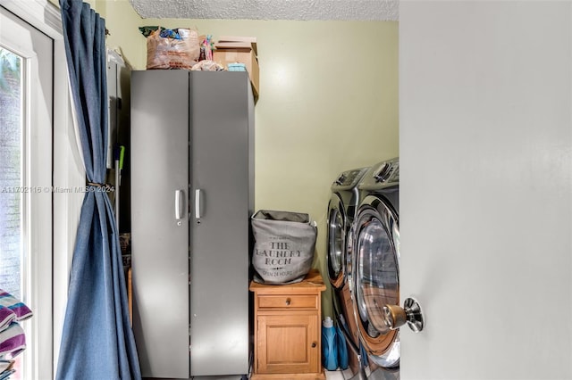 laundry room featuring a textured ceiling and washing machine and clothes dryer