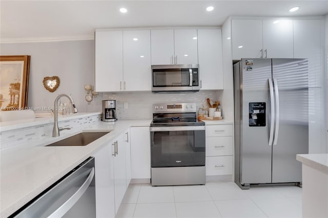 kitchen with decorative backsplash, appliances with stainless steel finishes, sink, white cabinetry, and light tile patterned flooring