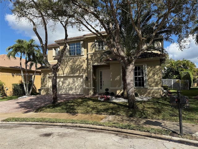 view of front of home with a garage, a tiled roof, decorative driveway, stucco siding, and a front yard