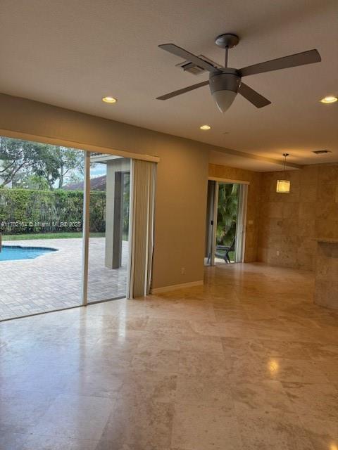 kitchen featuring sink, light stone countertops, appliances with stainless steel finishes, and a kitchen island with sink