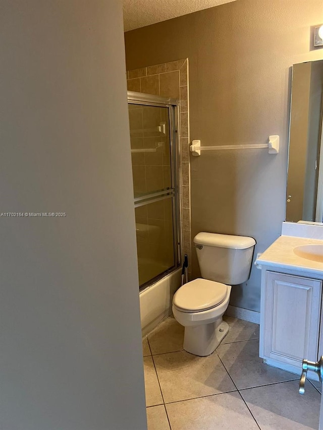 full bathroom featuring toilet, vanity, combined bath / shower with glass door, and tile patterned flooring